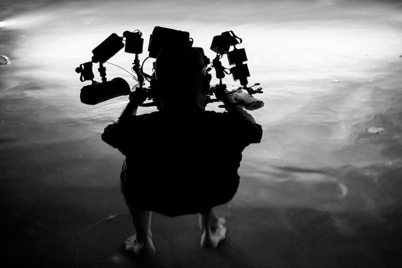rear-view-full-length-man-with-lighting-equipment-sea-night_1048944-29134540